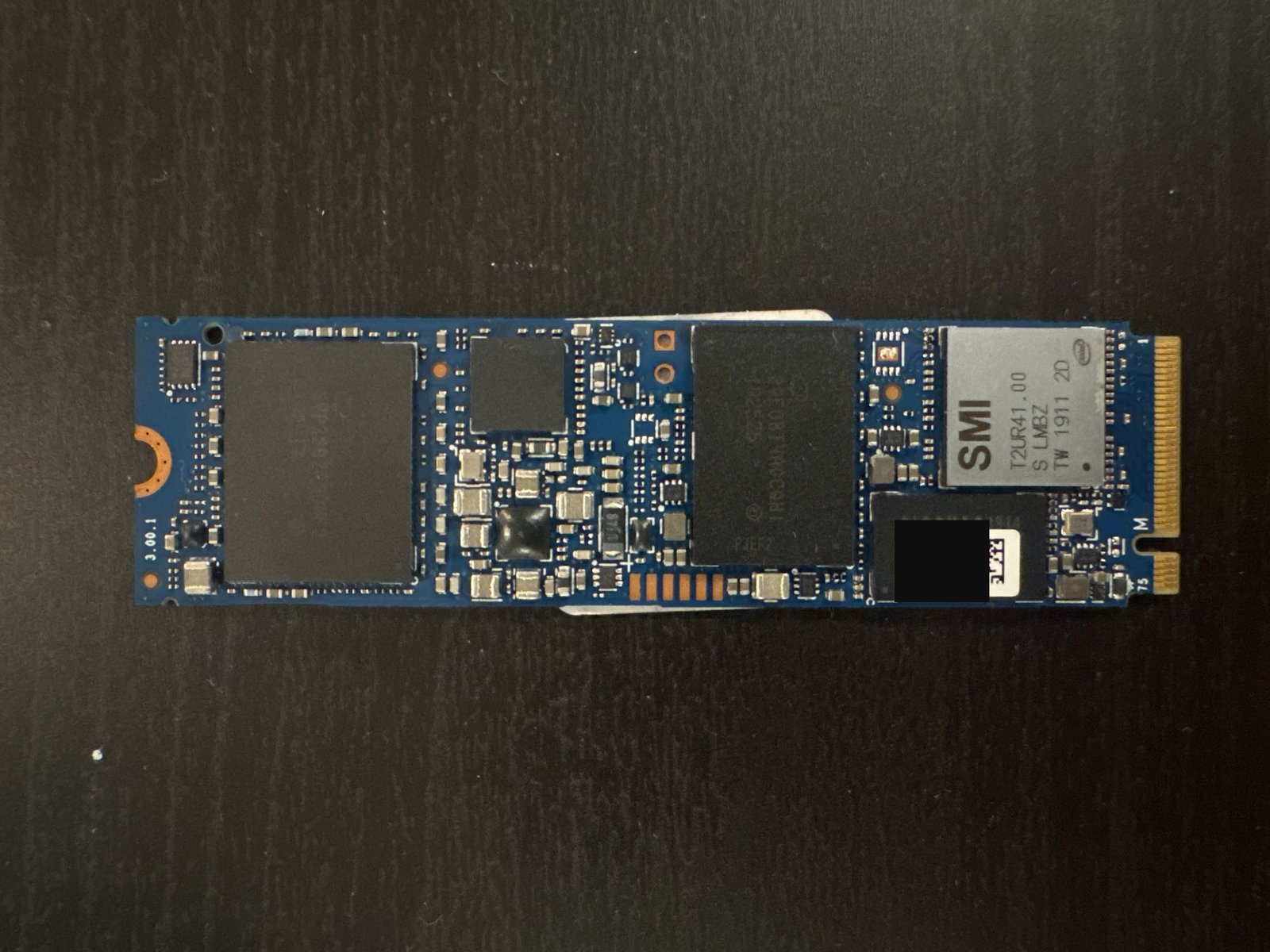 Intel Optane Memory H10 NVMe M.2 module showing the SMI controller, Optane and NAND packages, with the small manufacturing/serial label redacted
