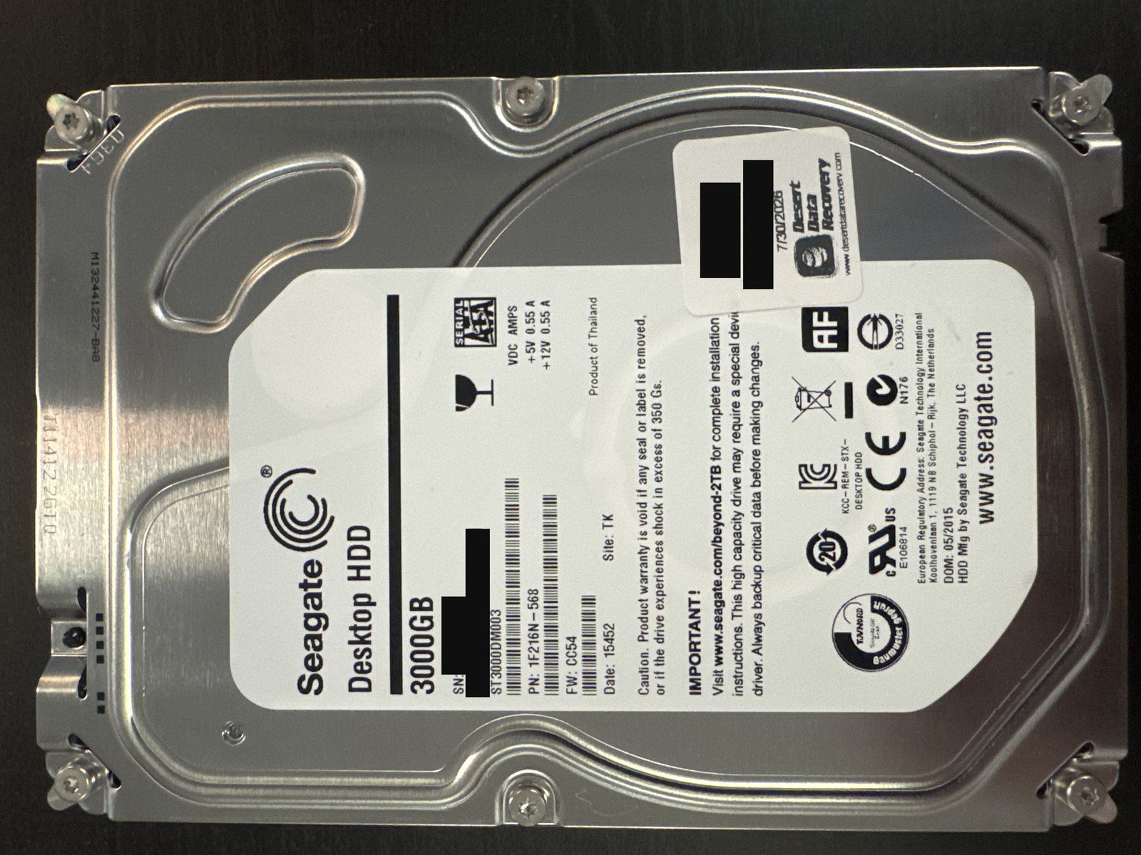 Seagate ST3000DM003 3 TB SATA hard drive label with serial number and barcode redacted, and the intake sticker case number and client name blacked out